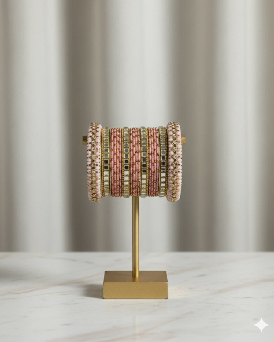 Bangle holder with pink and gold bangles on a neutral background